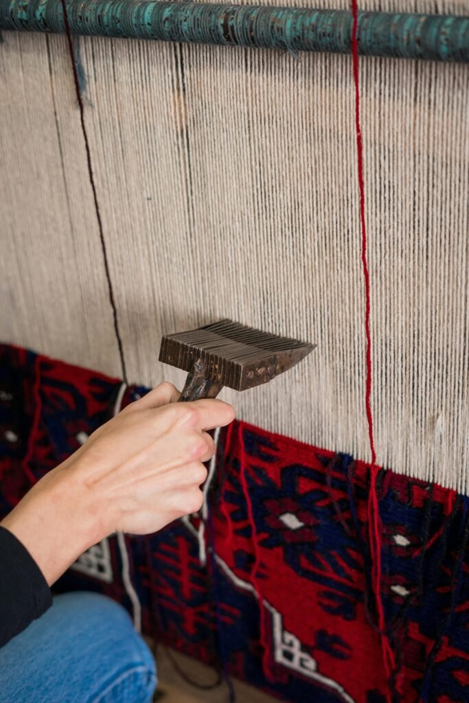 a man is weaving a blue and red persian rug